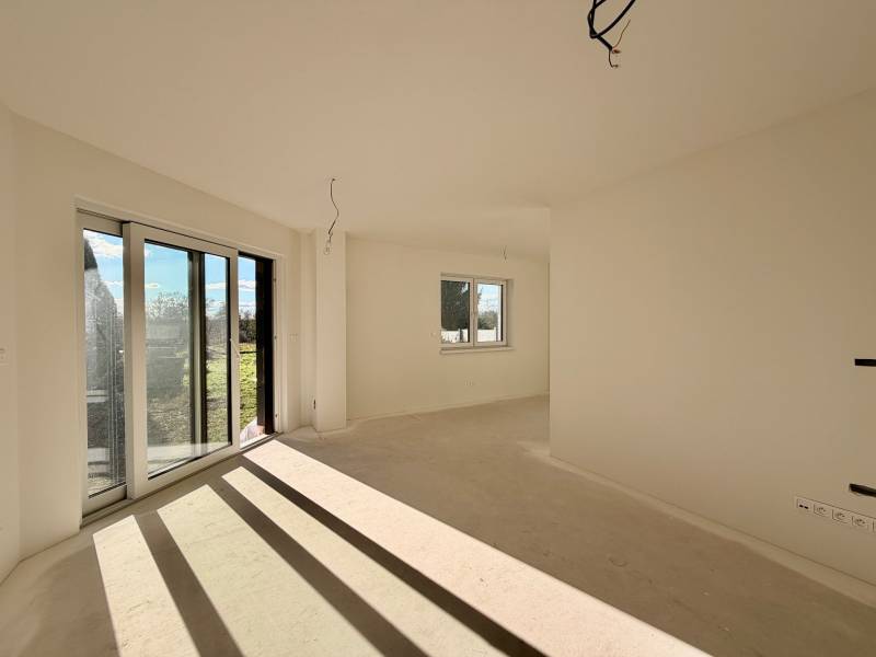 Tágas szoba nagy ablakokkal és kilátással egy családi házban.