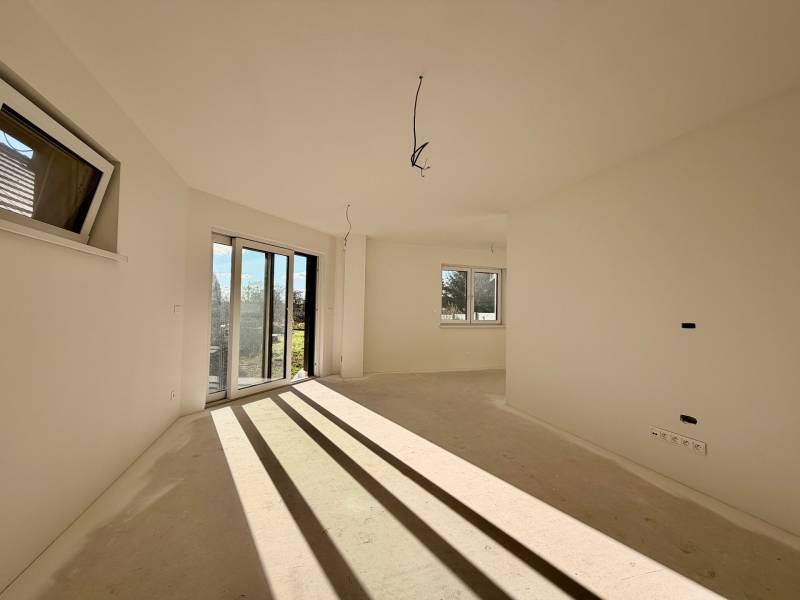 Tágas szoba egy családi házban nagy ablakokkal és kertre néző kilátással.