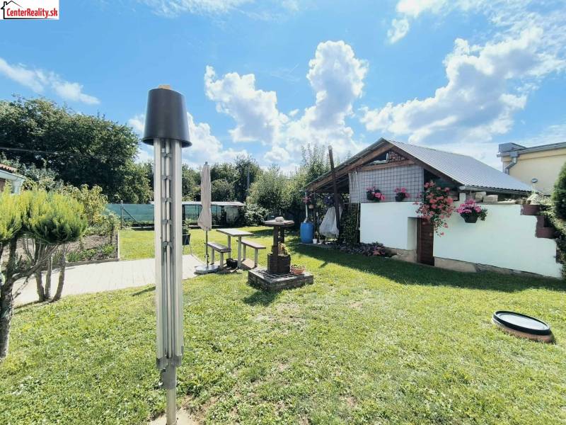 Kert Partizánske-ban, pavilonnal és virágdíszítéssel a családi ház mellett.