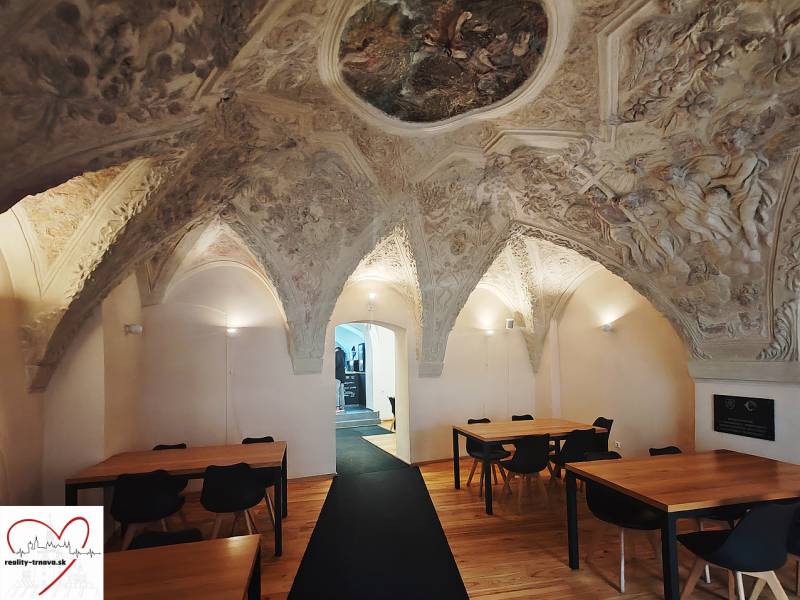 Gasztronómiai terek belső tere ornamentális mennyezettel és fa dekorációjú padlóval.