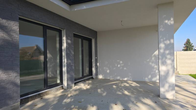 Egy családi ház terasza Pöstyénben nagy ablakokkal és kő dekorációval.