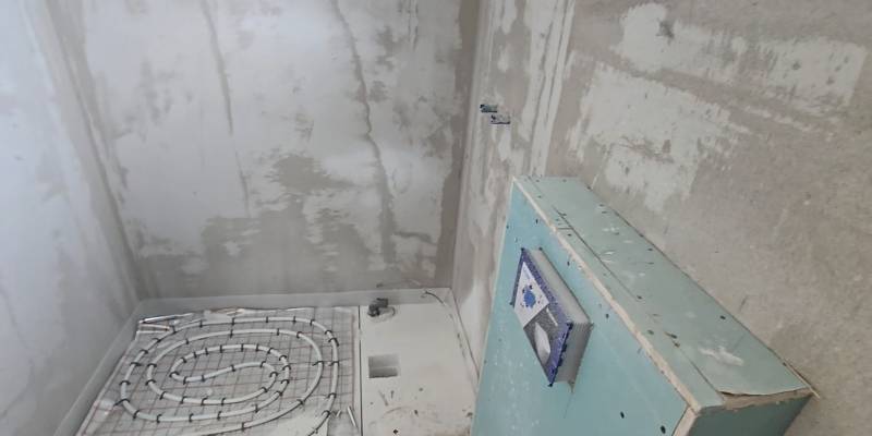 Padlófűtés telepítése egy családi ház fürdőszobájában.