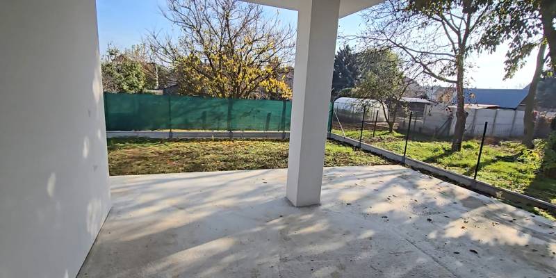 Családi ház Pöstyénben kerttel, bekerített udvar gyeppel és fákkal a telken.