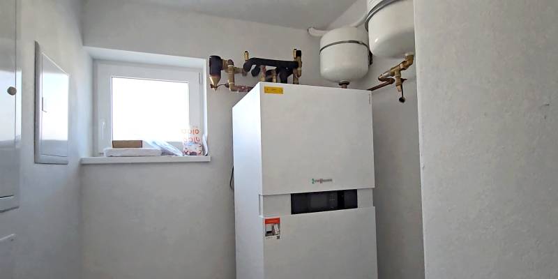 Kondenzációs kazán világos családi ház gépészeti helyiségében ablakkal.