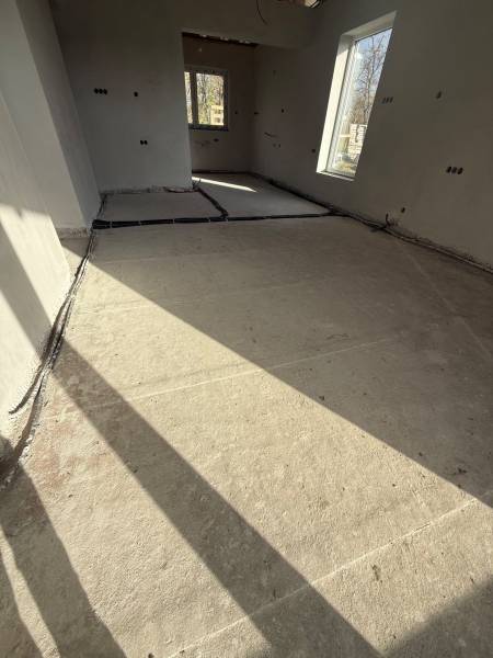 Családi ház belső tere betonpadlóval és nagy ablakokkal Pozsony mellett.