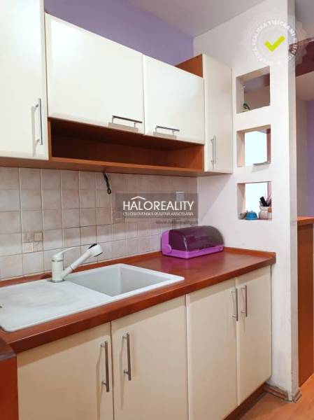 Konyhasarok a garzonlakásban mosogatóval és szekrényekkel.