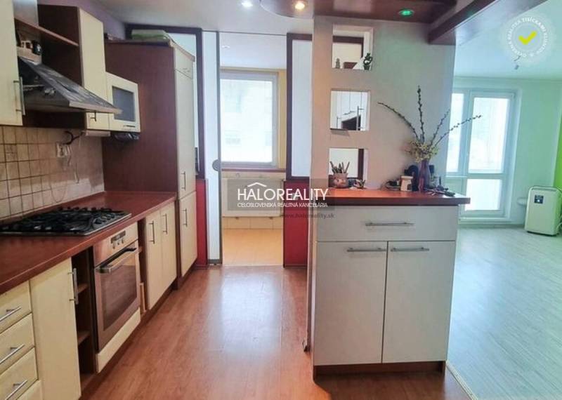 Konyha egy garzonlakásban, fa dekorációjú padlóval és világos belső térrel.