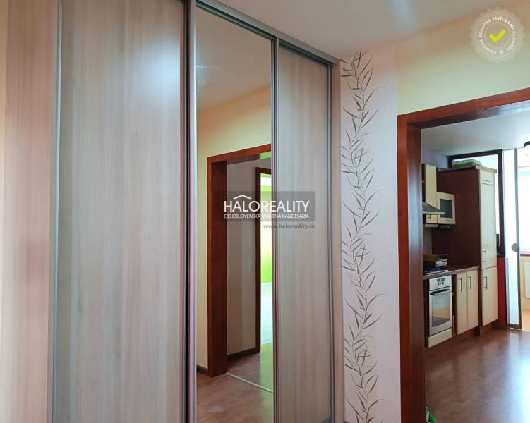 Garzonlakás konyhával, fa burkolattal és beépített szekrénnyel.