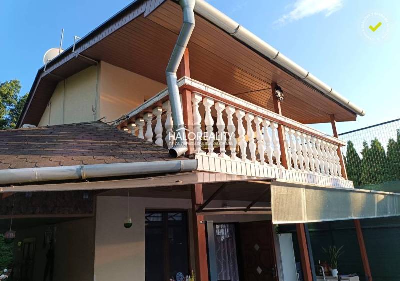 Ház Byštén terasszal és fa dekorációjú erkéllyel.