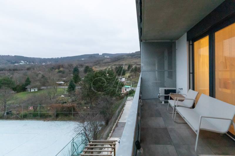 Erkély az egyszobás lakáson, kilátás a természetre, kilátás a kertekre és fákra.