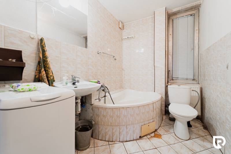 Kúpeľňa s vaňou, umývadlom a práčkou v rodinnom dome.