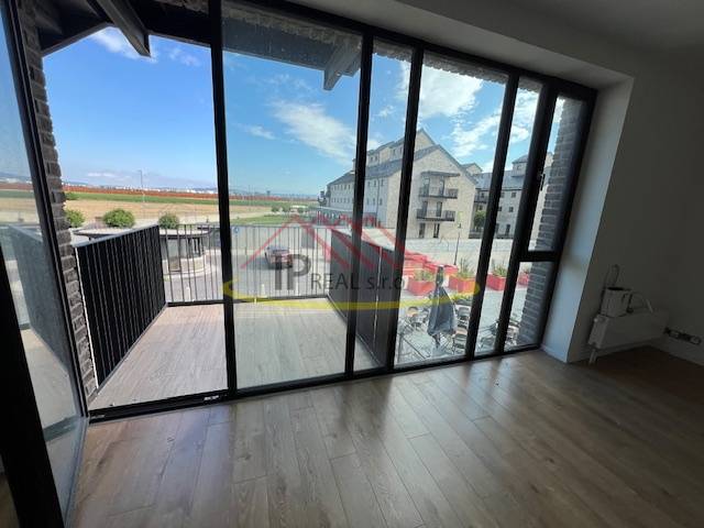 2 szobás lakás belső tere nagy ablakokkal és fa dekorációjú padlóval.