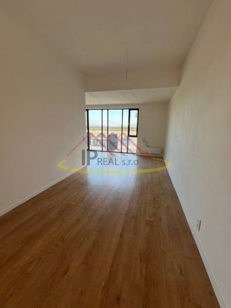 Világos szoba fa mintázatú padlóval egy kétszobás lakásban.