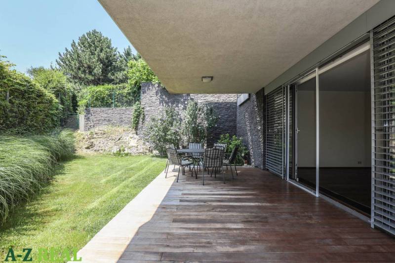 Terasz fa dekor padlóval, kerti ülőgarnitúrával és növényekkel a 3 szobás lakás mellett.