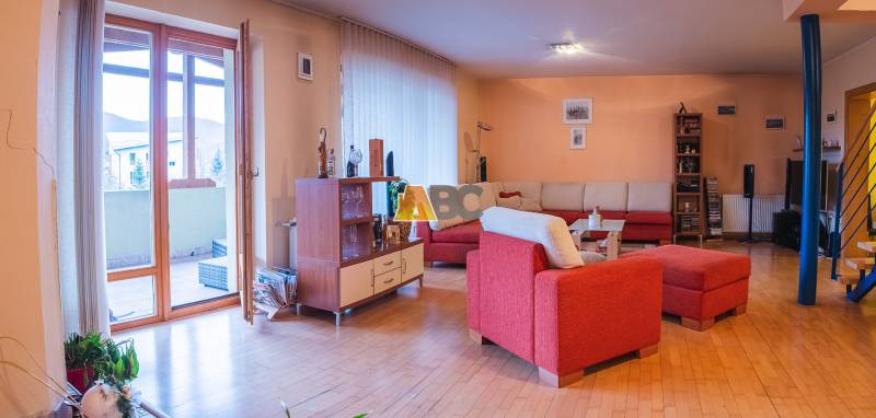 Nappali egy villában piros kanapéval és fa dekorációjú padlóval.