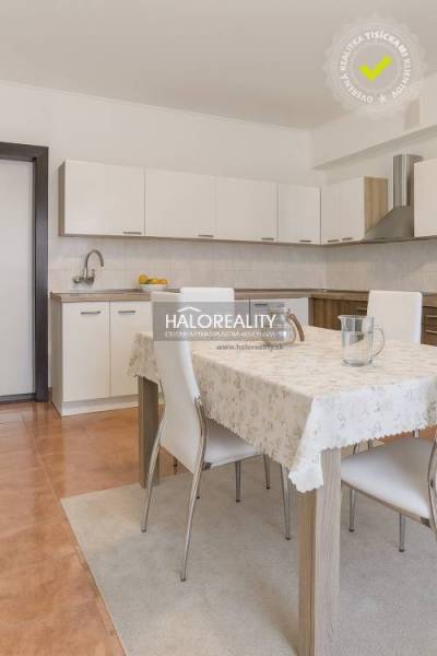 Konyha családi házban fehér konyhabútorral és étkezőasztallal négy székkel.