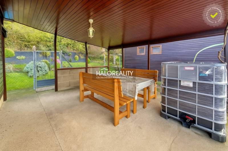 Fedett terasz asztallal, padokkal és kilátással a kertekre Bytčában.