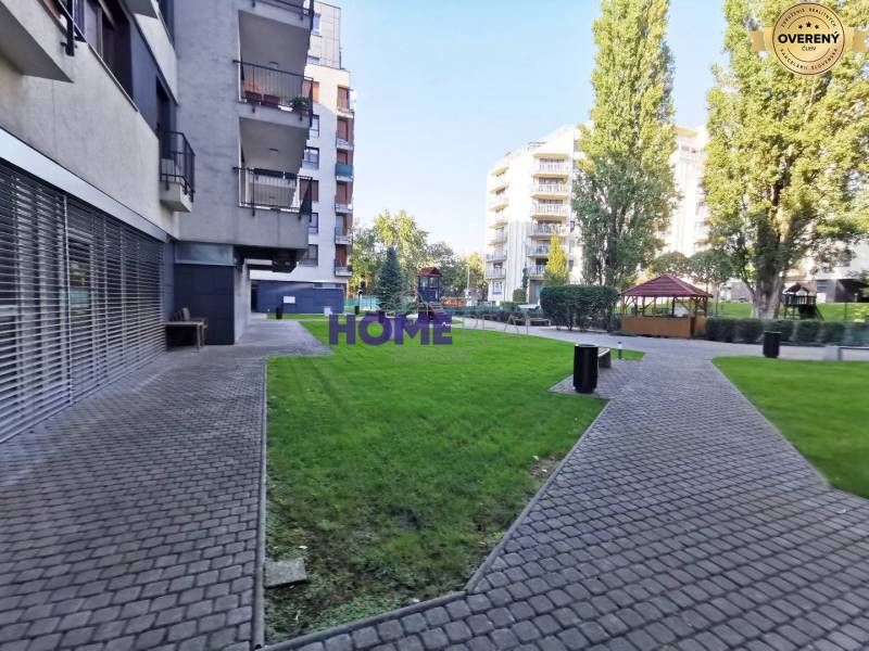 Kilátás egy lakóövezetre járdával és zöld gyepfelületekkel Pozsonyban, a Drieňová utcában.