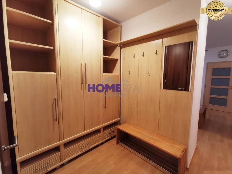 Előszoba egy kétszobás lakásban, fa dekorációjú bútorokkal és tükörrel.