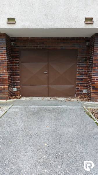 Garázs a mező előtt Trencsénben barna kapukkal és téglaburkolattal, 3 szobás lakás.