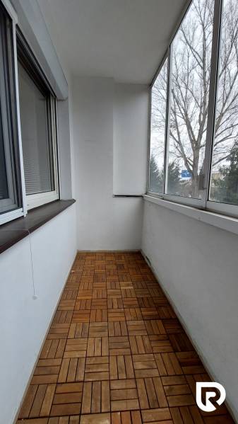 Üvegezett loggia fa dekor padlóval egy 3 szobás lakásban.