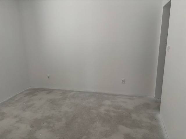 Szoba fehér falakkal és semleges szőnyeggel egy családi házban.