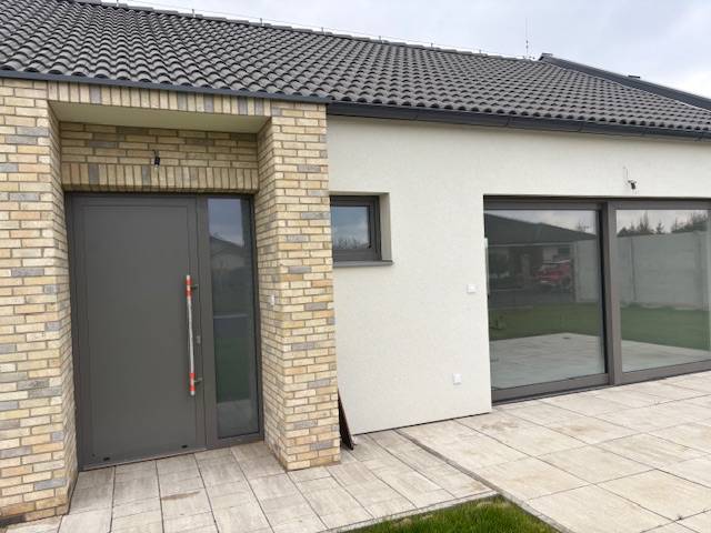 Családi ház Tomášovban, a Fialkova utcában, téglaburkolattal és tágas üvegajtókkal.