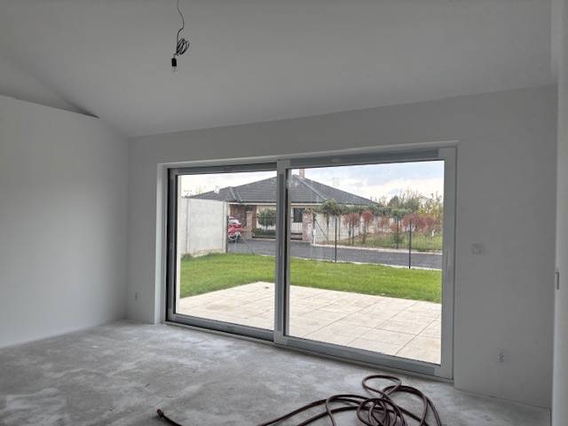 Családi ház üvegfallal és kilátással a kertre.