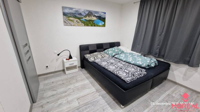 Hálószoba családi házban ággyal, éjjeliszekrénnyel és fa dekoros padlóval.