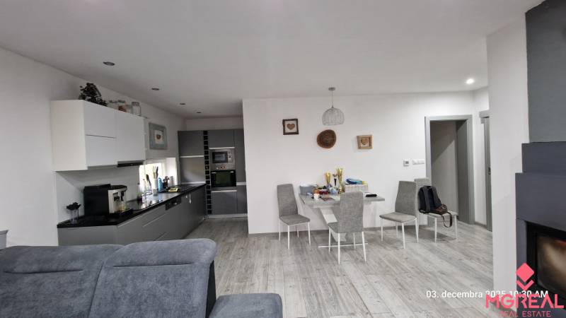 Családi ház belső tere konyhával, étkezőasztallal és fa dekorációjú padlóval.