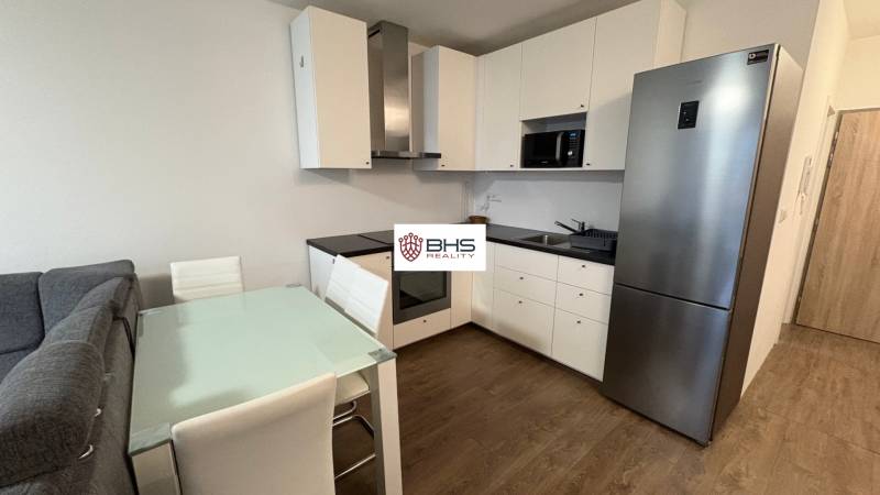 Konyhasarok az egyszobás lakásban fa dekor padlóval és étkezőasztallal.