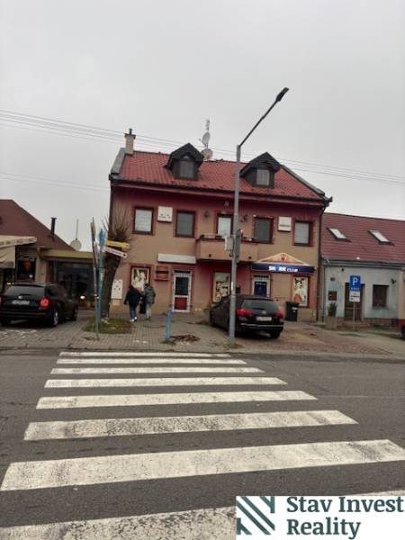 Kétszintes épület irodákkal és üzlethelyiségekkel Szenc városában.