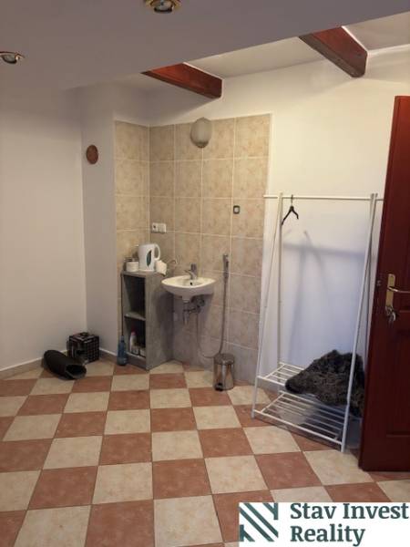 Iroda belső mosdóval, fogassal és csempézett padlóval.