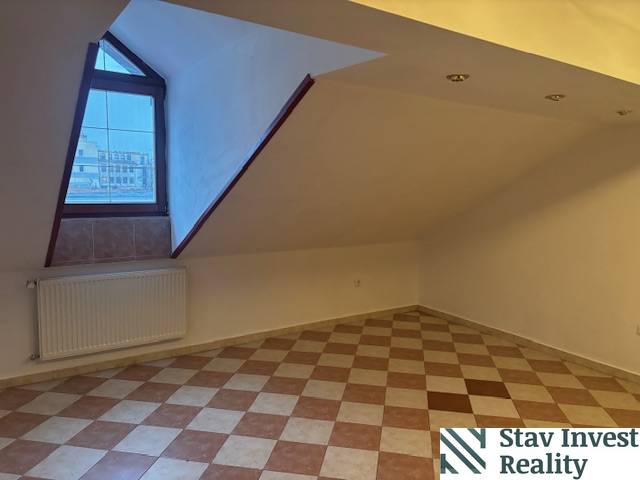 Tetőtéri iroda padlóburkolattal és ablakkal, radiátoros fűtéssel.