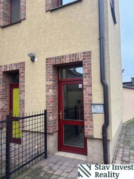 Sencen találhatóak irodák a téglából épült épületben, amelynek piros ajtaja van.