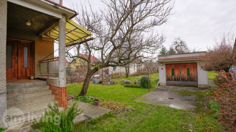 A Dubnica nad Váhom-i Nerudova utcai családi ház előtt van egy kert egy fával.