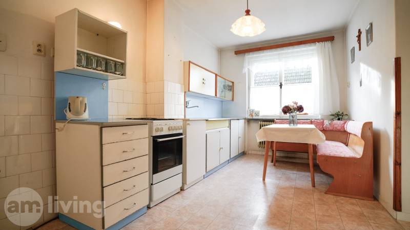 Konyha családi házban klasszikus felszereléssel, sarokban elhelyezett ülőhellyel és ablakkal.