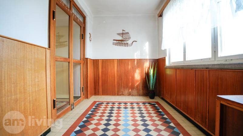 Családi ház belső tere fa dekorációval és színes csempével, növénnyel díszítve.