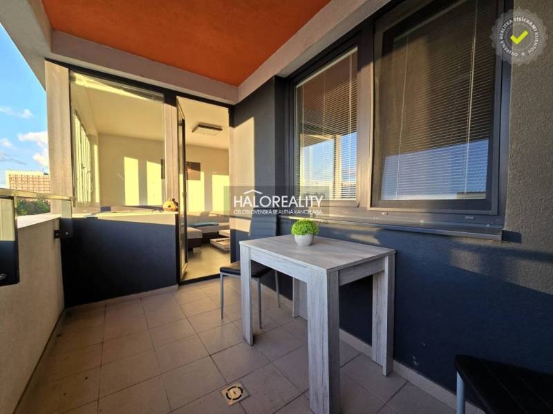 A kétszobás lakás erkélye Nagyszombatban, kilátással és teraszon lévő asztallal.