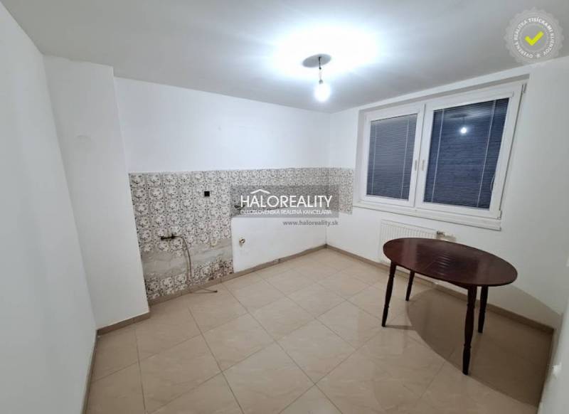 Szoba családi házban fehér falakkal, ablakkal és csempékkel.