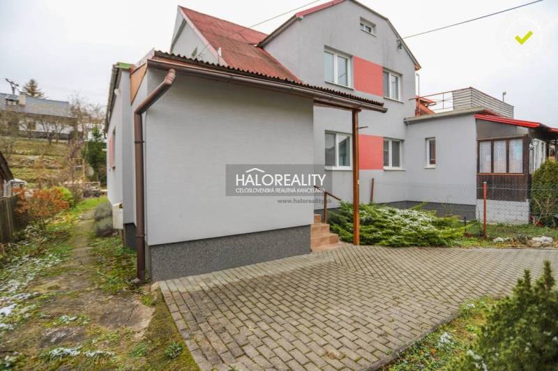 Családi ház Brvništeben piros tetővel és kövezett bejárati úttal.