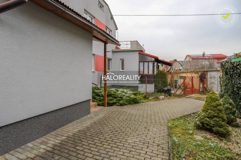 Burkolt járda és zöldterület egy családi ház mellett Brvnište-ben.