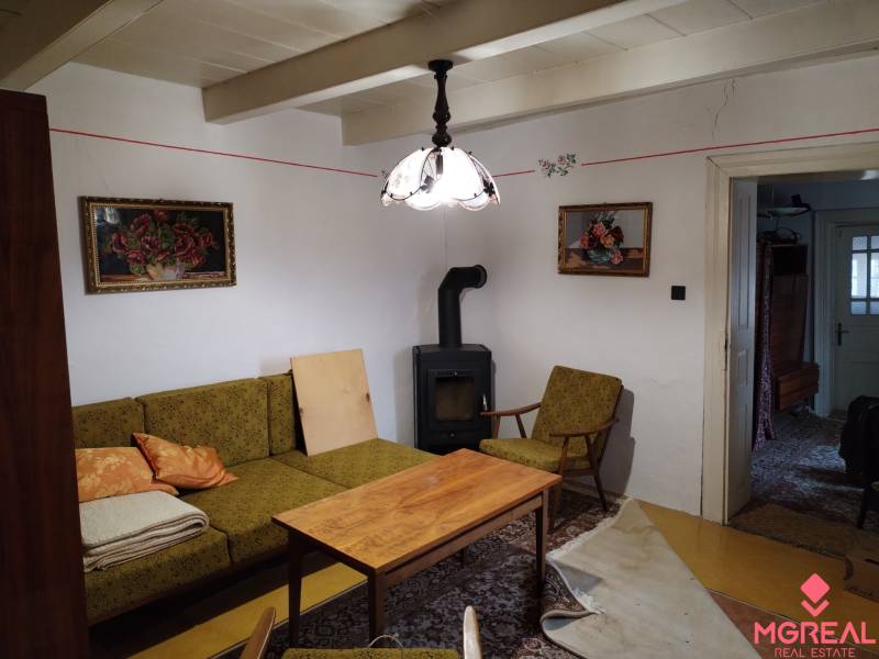 Családi ház nappalija cserépkályhával, antik bútorokkal és dekorációkkal.