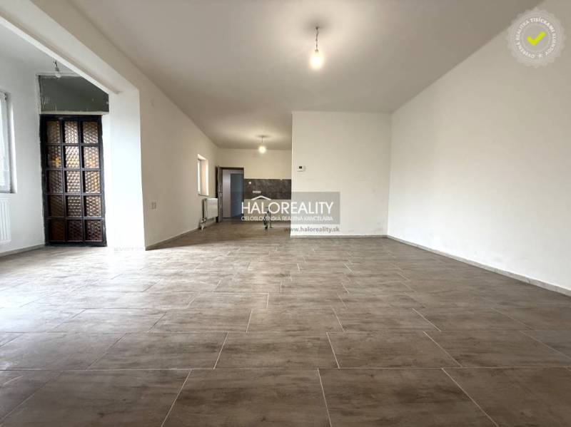 Tágas belső tér nagy ablakokkal és fa dekorációjú padlóval egy családi házban.