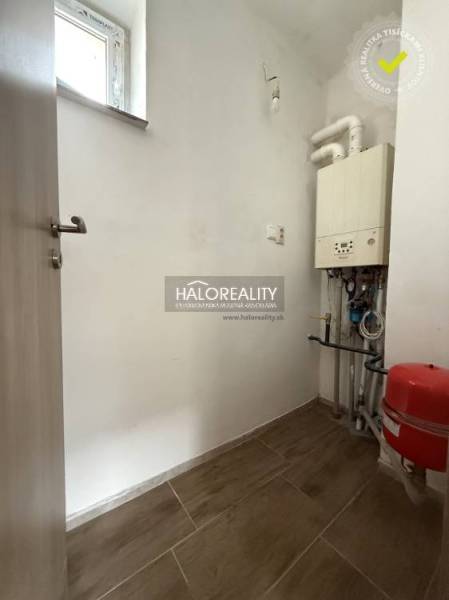 Családi ház technikai helyisége kazánnal és fa dekorációjú padlóval.