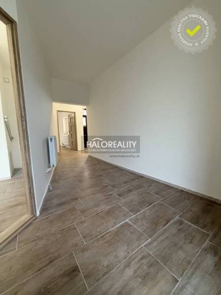 Családi ház belső tere fa dekorációjú padlóval és fehér falakkal.