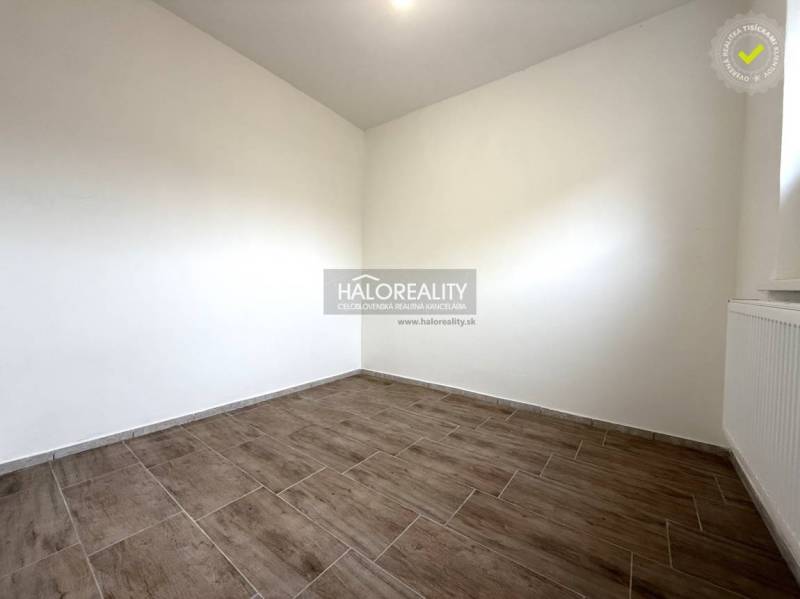 Szoba fa dekorációs padlóval egy családi házban, világos falak, radiátor.