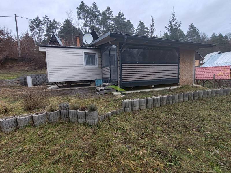 Újkelcsén, a Fő utcán található ház, amelyet gyep és szegélykövek vesznek körül.