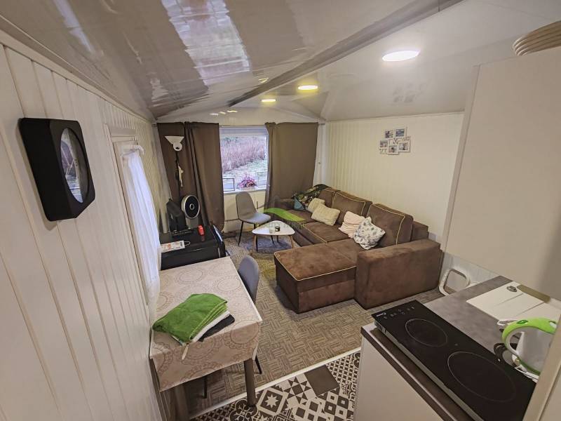 A ház belső tere kanapéval, étkezőasztallal és felszerelt konyhával.