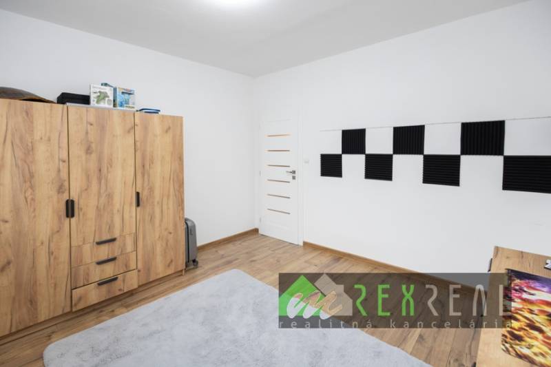 Gyerekszoba fa hatású padlóval és szekrénnyel egy háromszobás lakásban.